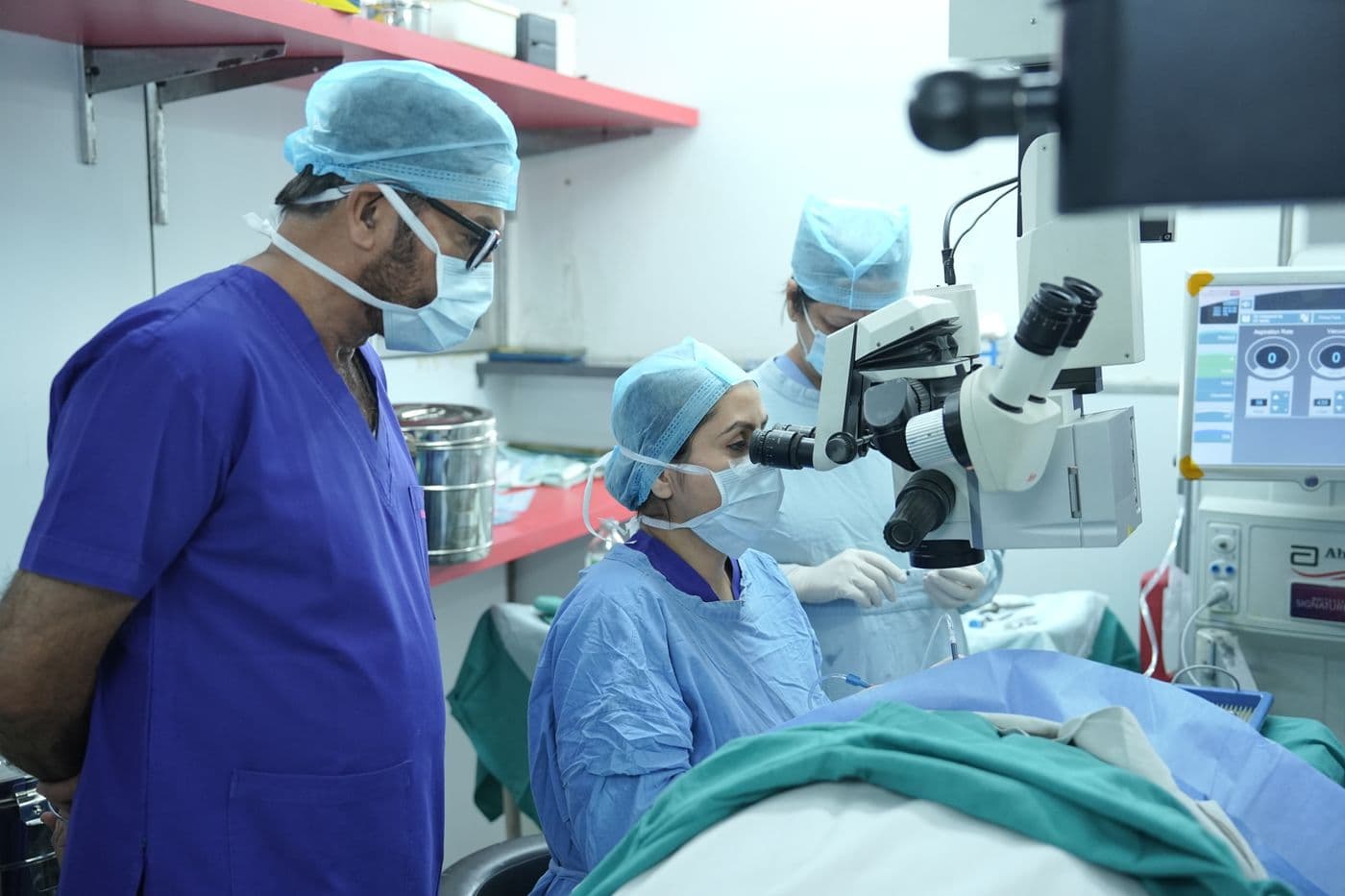 A surgical team at the operating microscope during eye surgery